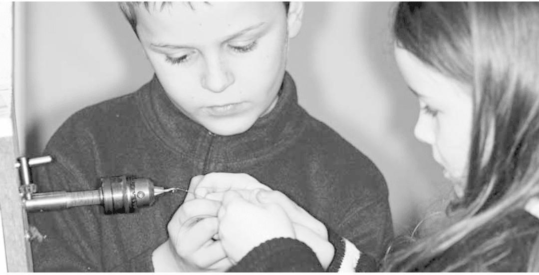 Two Children using a drill to replace harpsichord string